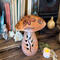This shows a handmade mushroom decoration. Made from a gourd, it has a fern carved in the stock and wood burned bee artwork on top. 